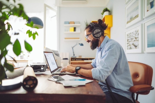 Sie sehen den Screen unseres Kurses Effizientes Arbeiten im Home Office. Darauf abgebildet ist ein Mann wie er uihause am Laptop sitzt und arbeitet.